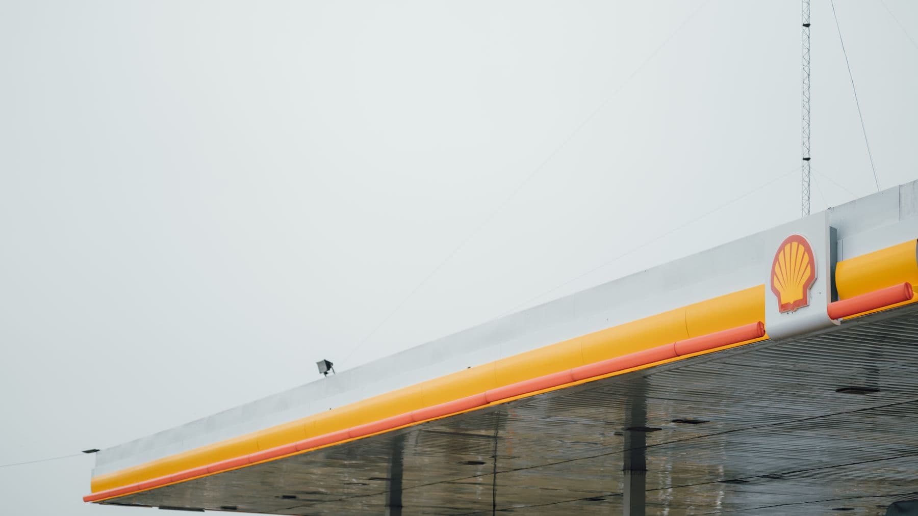 Dach einer Shell-Tankstelle gegen bewölkten Himmel – Orientierungspunkt auf dem Weg zur Autobahnauffahrt
