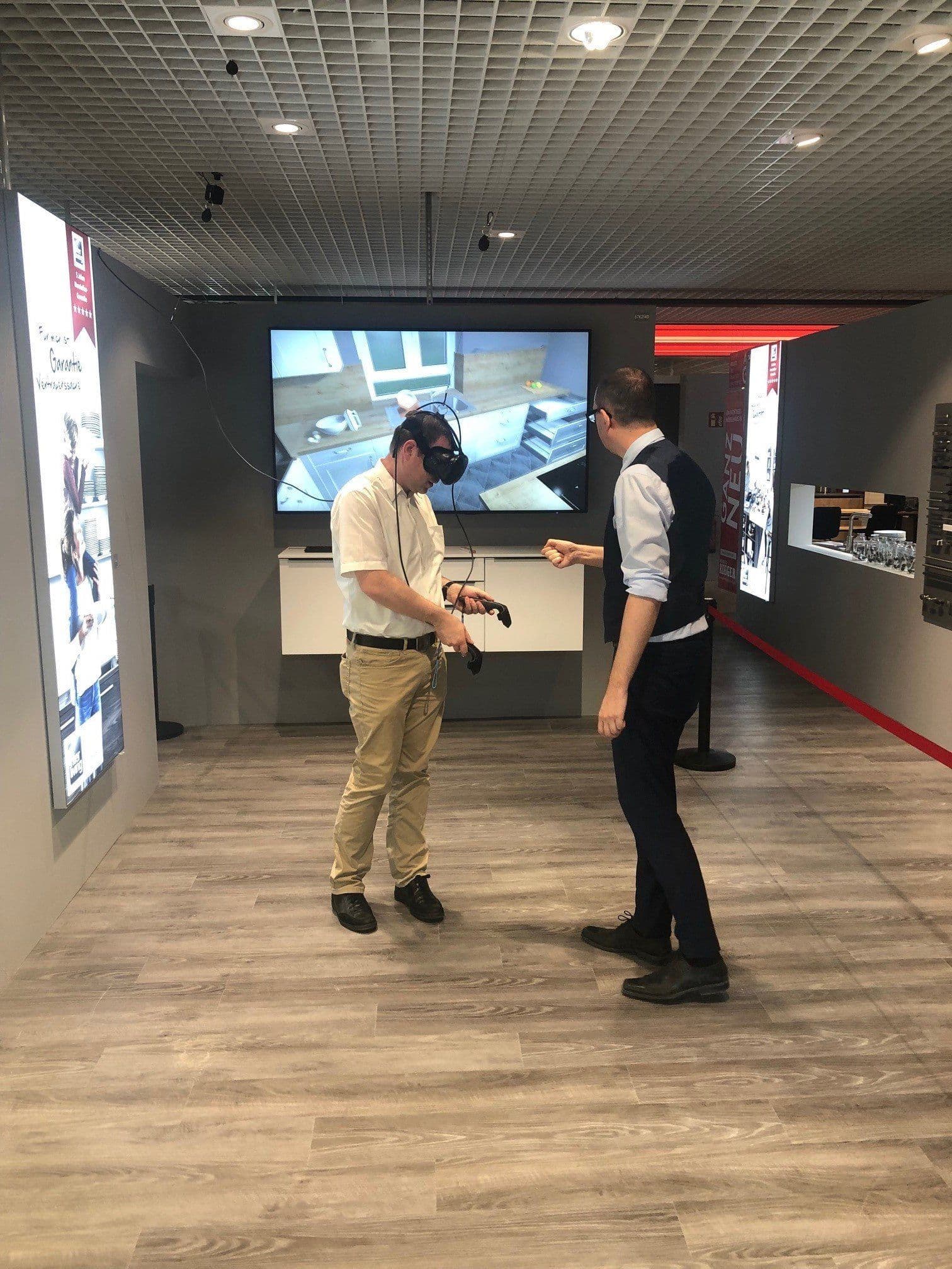 Kunde erlebt seine geplante Küche mit der VR-Brille, begleitet von einem Küchenberater