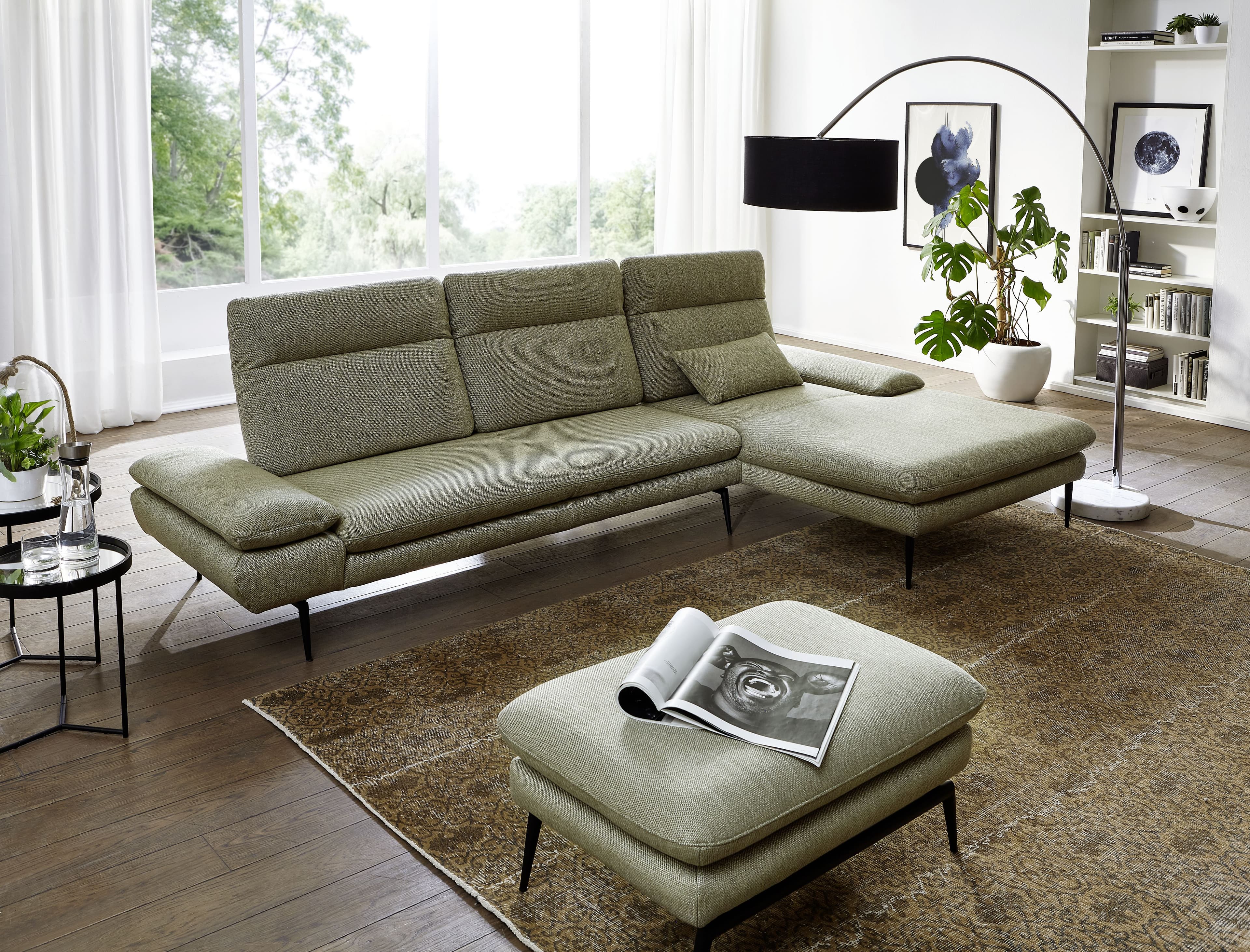 Grünes Ecksofa mit passendem Hocker im Wohnzimmer