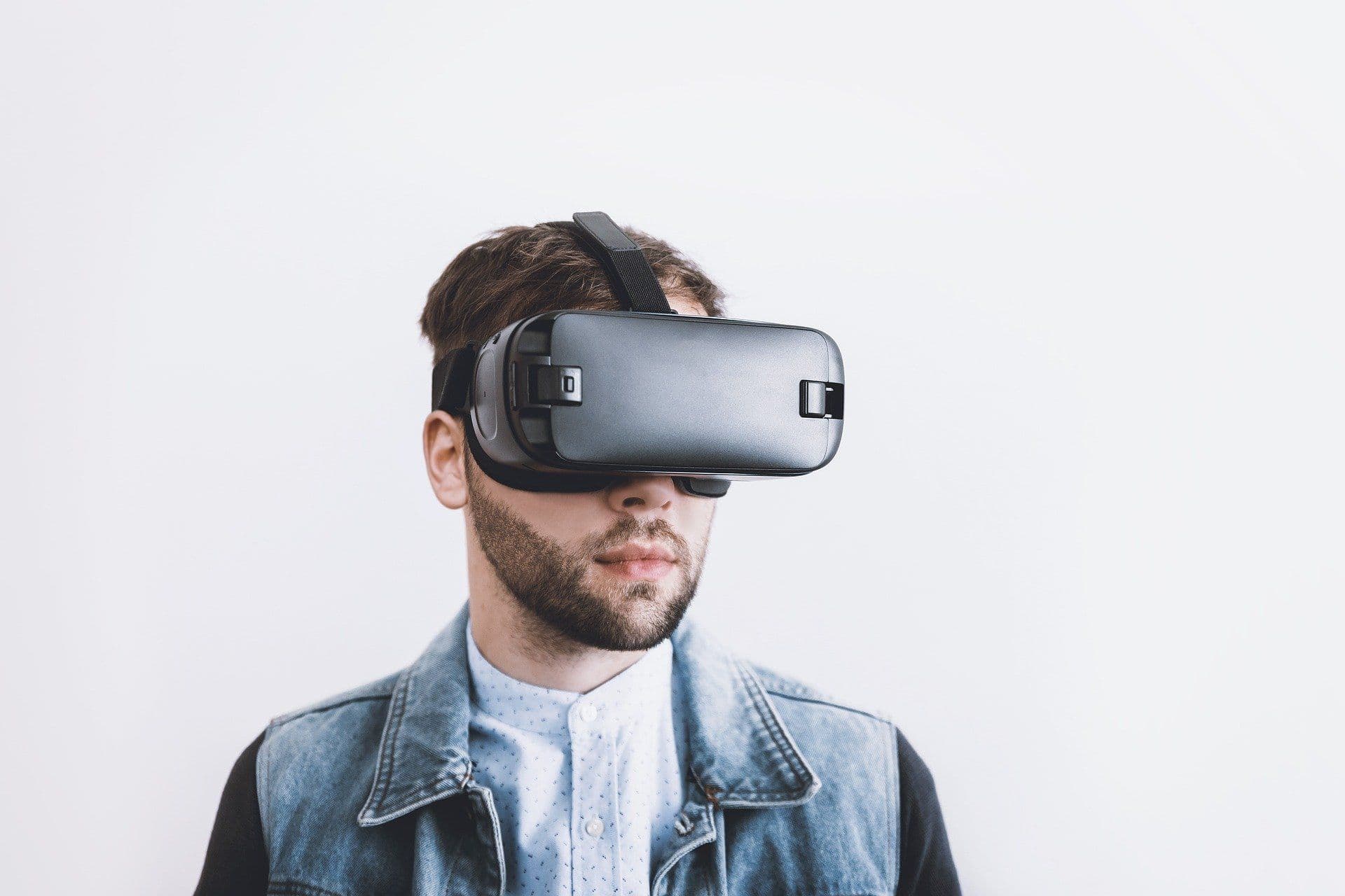Mann mit Virtual-Reality-Brille vor hellem Hintergrund